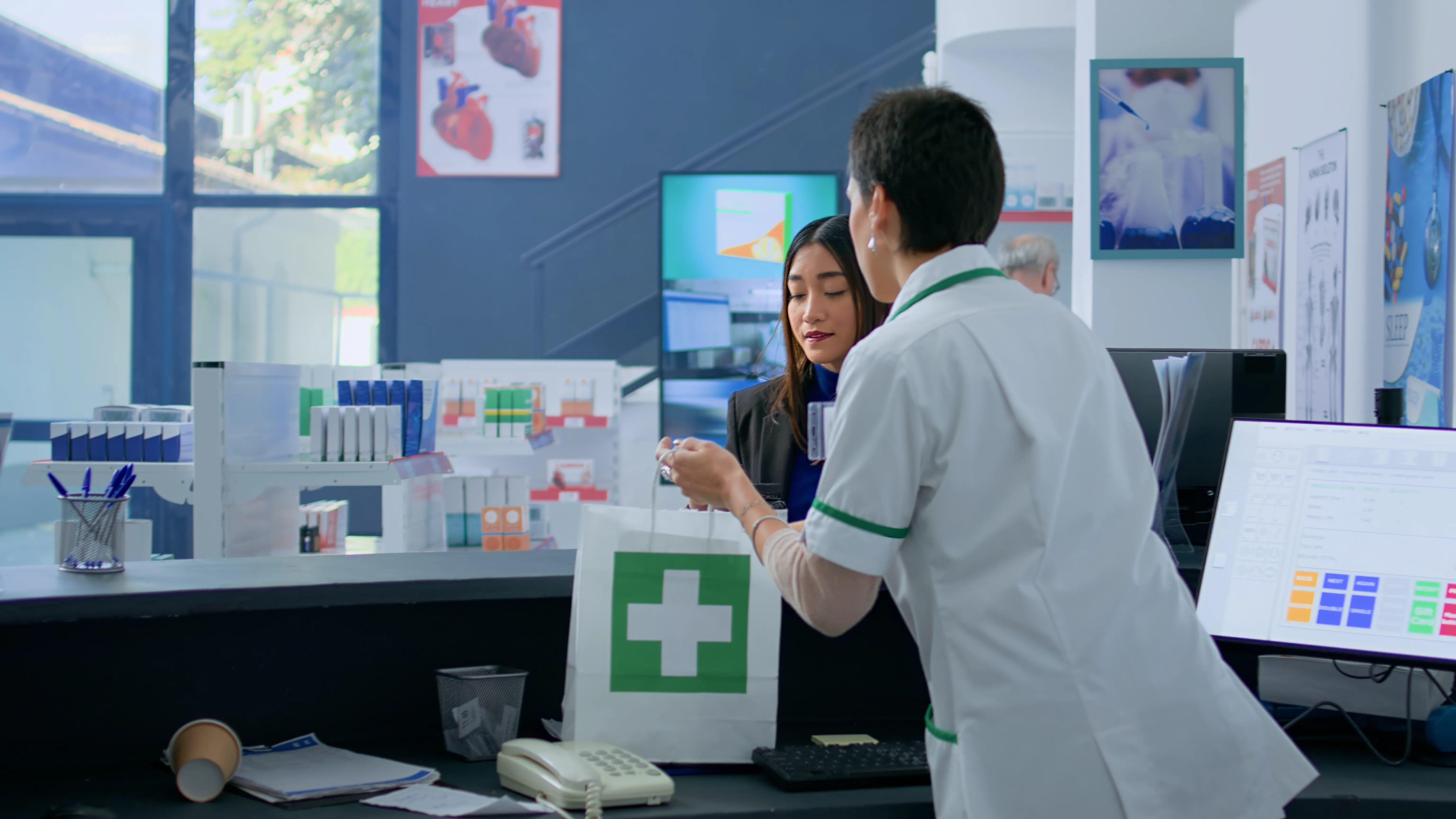 Pharmacist using mobile pharmacy CRM software by PharmCRM for prescription management and customer support.