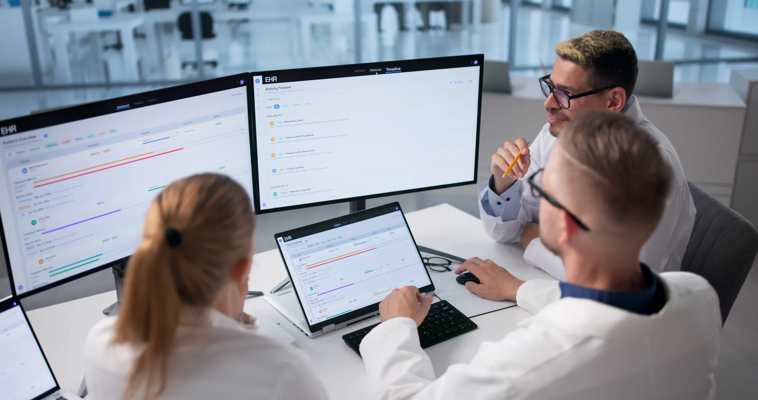 Medical team reviewing clinical records on dual monitors integrated with a patient management system.