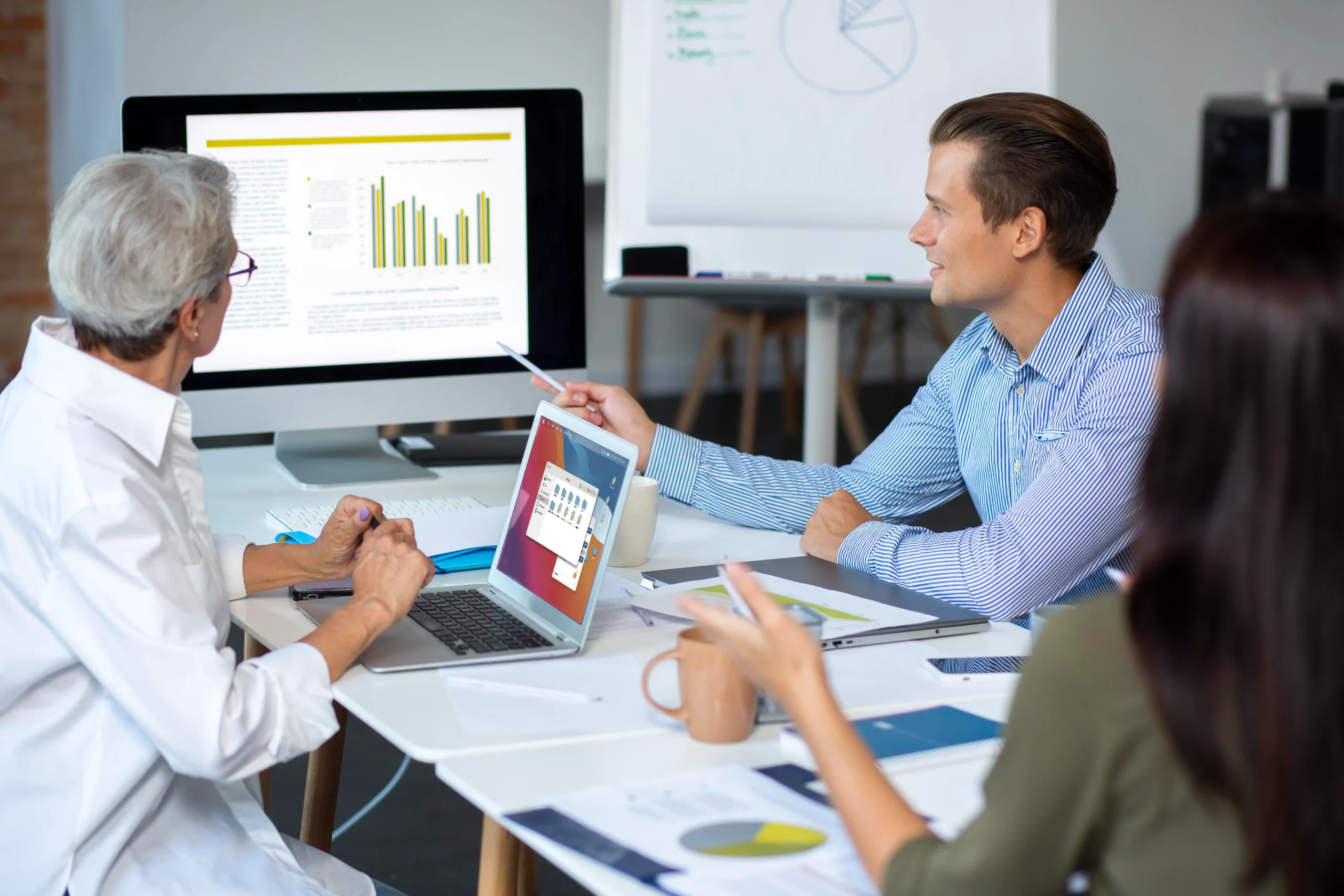 Doctors collaborating at a desk using laptop systems to streamline tasks with healthcare workflow automation.