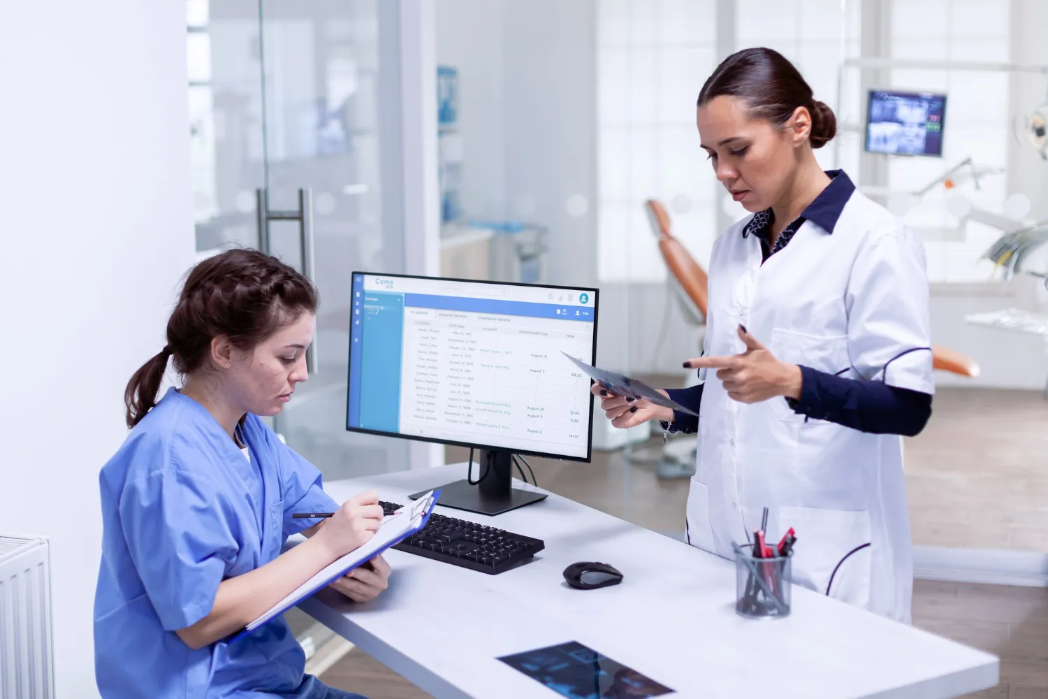 Doctor and nurse reviewing an X-ray and patient list to streamline clinical workflow management.