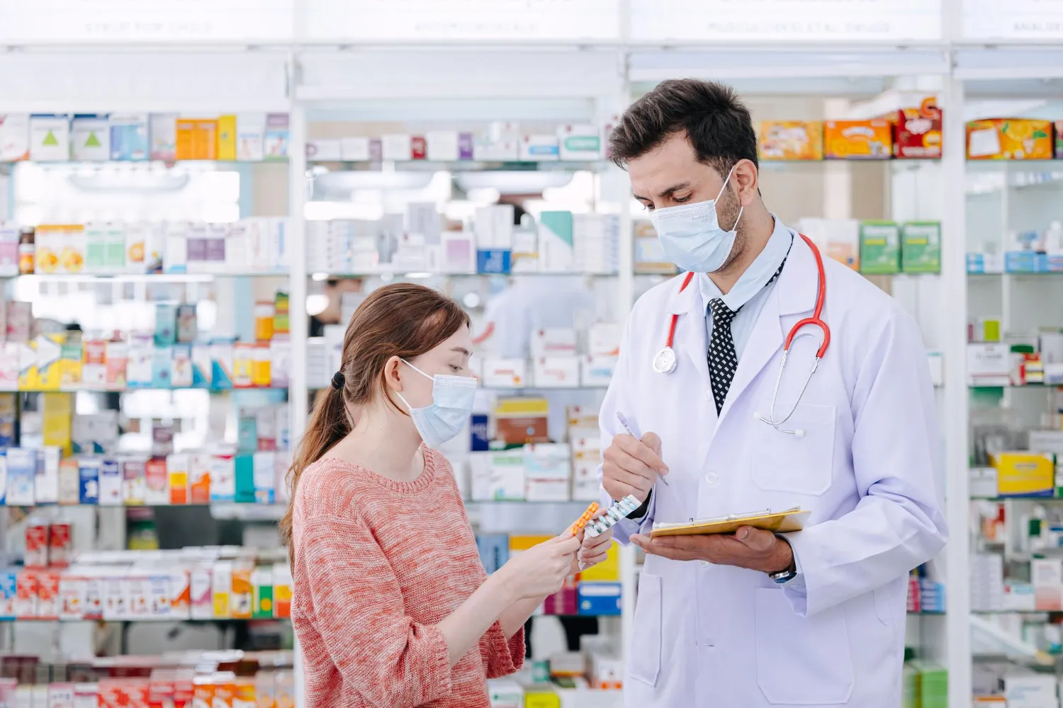 Pharmacist checking prescription information on a counter system integrated with a CRM for Healthcare.