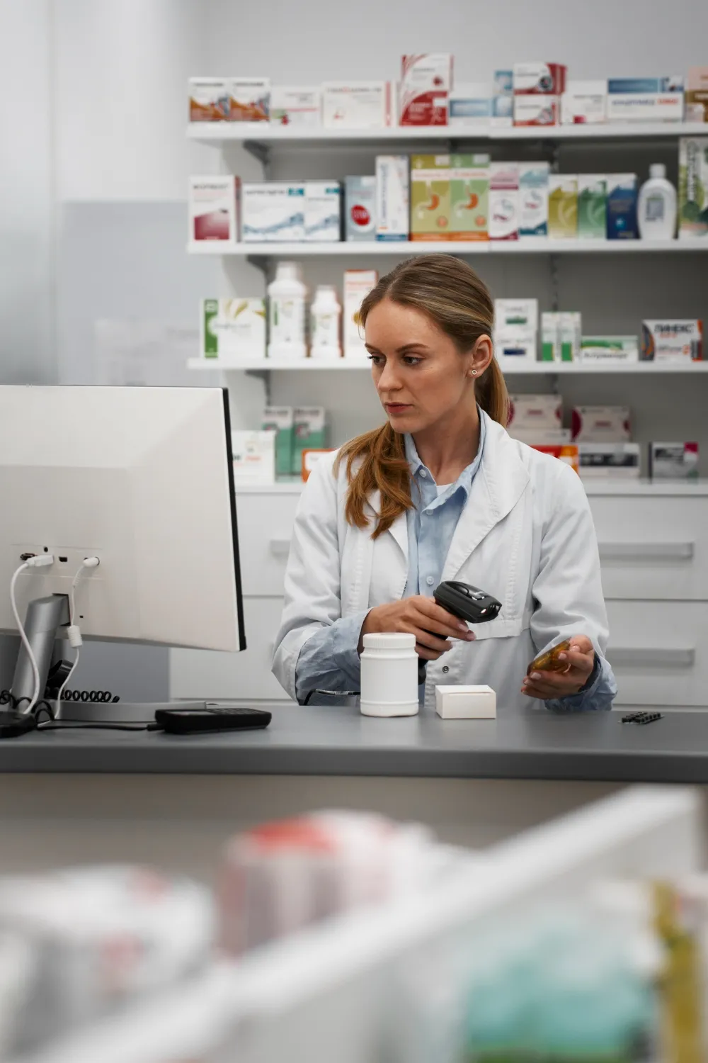 Female pharmacist holding a digital tablet displaying patient records using a Healthcare CRM system.