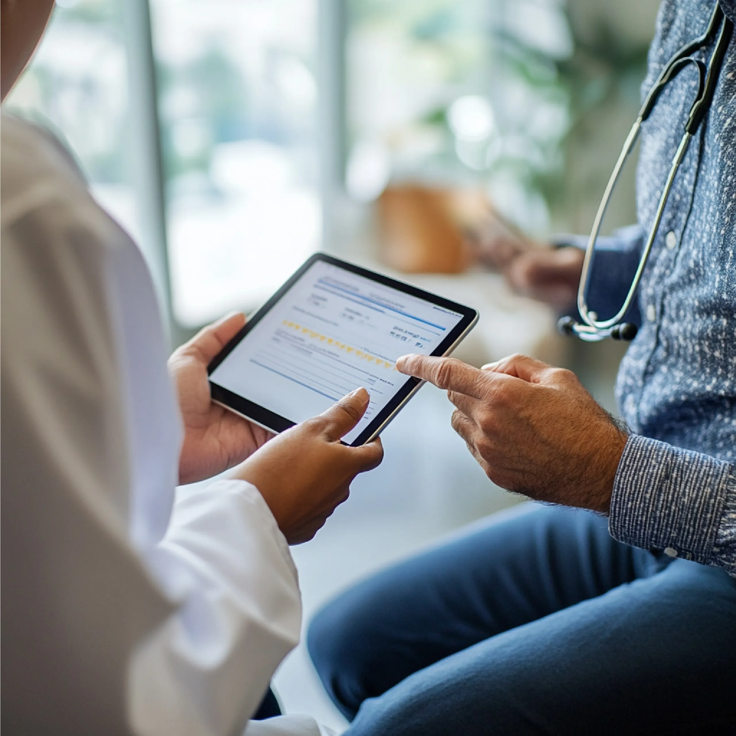Doctor sharing treatment details with a patient on a tablet using an interactive patient engagement platform.