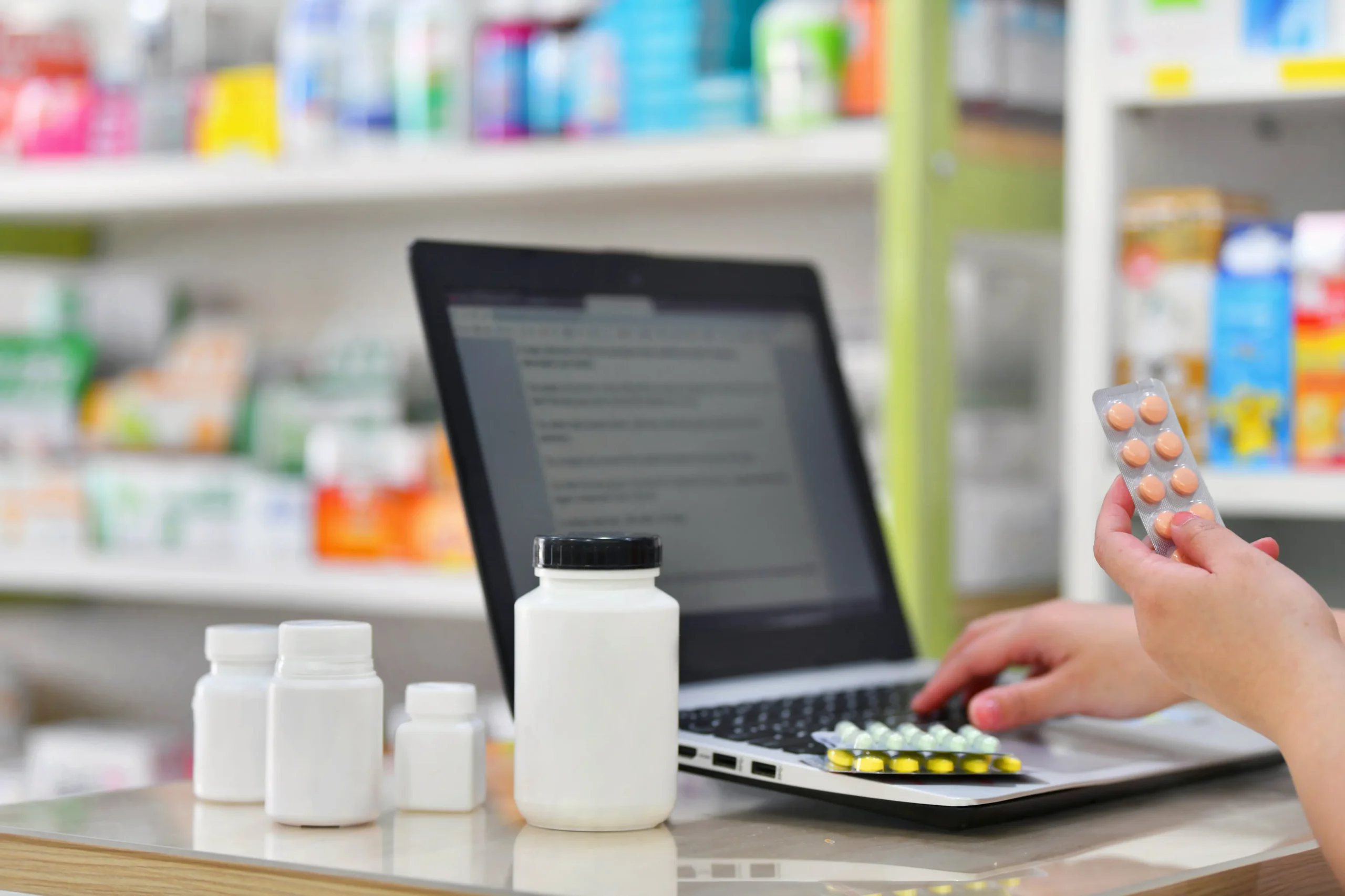 Pharmacy staff verifying incoming physician prescription entries using referral management software.